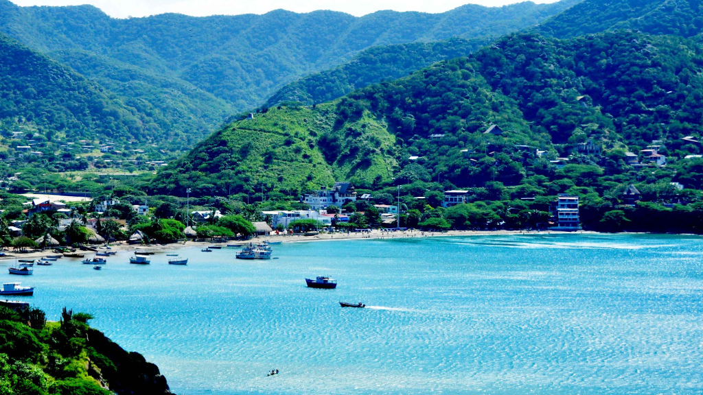 View of Santa Marta, Colombia. A blue harbour, dotted with boats, before rolling green mountains